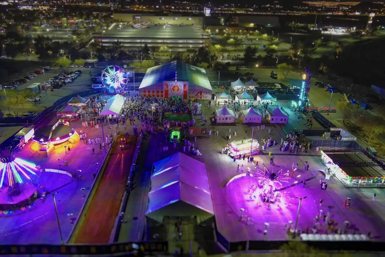 Aerial night festival with Ferris wheel, carnival rides, colorful lights